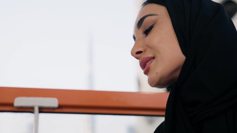 كافيهات ومطاعم  في الامارات العربية المتحدة، قضاء وقت الفراغ باحتساء المشروب المفضل, تناول الأعشاب الشتوية الدافئة، الاستمتاع بالمشروبات الساخنة، تصوير مقرب لامراة اماراتية ترتدي العباءة والحجاب تجلس على اريكة مريحة تقوم بشرب القهوة في المقهى