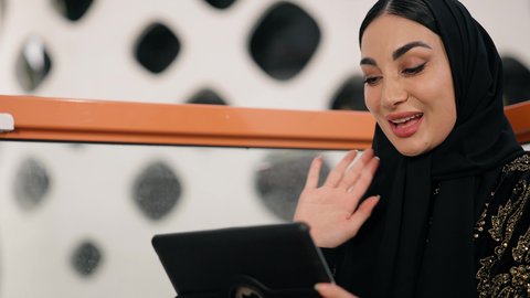 ايماءات التركيز والاندماج، ادارة الأعمال وانجاز المهام المطلوبة، العمل عن بعد،  مهنة ووظيفة نسائية،  تصوير مقرب لإمرأة عربية خليجية اماراتية محجبة ترتدي عباءة سوداء تستخدم الحاسوب المحمول، استخدام جهاز تقني حديث ومتطور