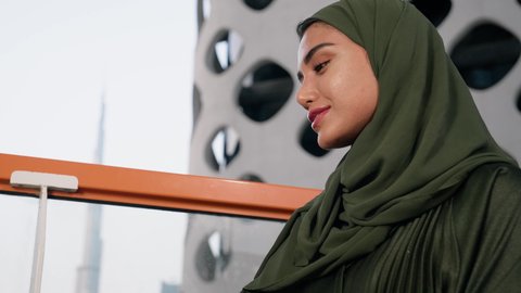 مطاعم وكافيهات  في الامارات العربية المتحدة، قضاء وقت الفراغ باحتساء المشروب المفضل, تناول الأعشاب الشتوية الدافئة، الاستمتاع بالمشروبات الساخنة، تصوير مقرب لامراة اماراتية ترتدي العباءة والحجاب تجلس على اريكة مريحة تقوم بشرب القهوة في المقهى