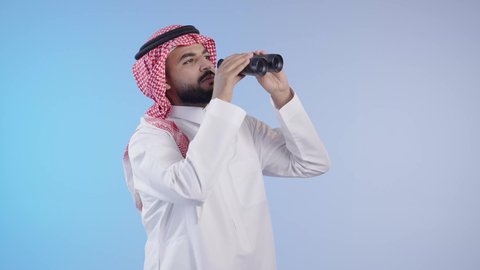 حب المغامرة والاستكشاف، التخطيط المستقبلي للأهداف والطموحات، شاب عربي خليجي سعودي يرتدي الثوب التقليدي والشماغ ينظر من خلال المنظار ثنائي العينين، رؤية الاشياء البعيدة عبر التلسكوب