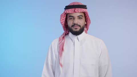 التعارف و الصداقه وتكوين علاقات, إلقاء التحيه والسلام, رجل عربي خليجي سعودي يرتدي الثوب التقليدي والشماغ يقوم بمد كفه للمصافحة, مفهوم الاستقبال والترحيب, النظر الى الكاميرا بايماءات السعادة والسرو