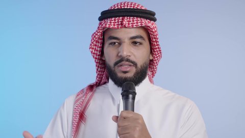 تبادل الحوارات والتواصل الفعال، رجل عربي خليجي سعودي يرتدي الثوب التقليدي والشماغ يحمل بيده مايك يقوم بإلقاء الخطابات، إجراء المقابلات وطرح الأسئلة, تقديم الأفكار و مناقشتها