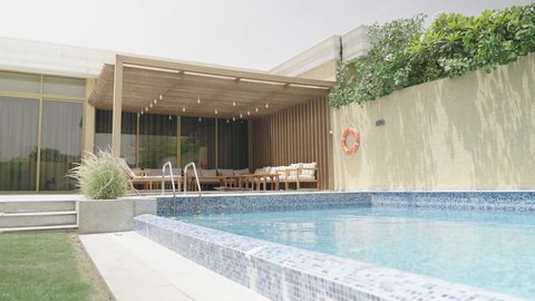 Sitting and enjoying in the pool, one of the luxury chalets in the Sultanate of Oman, water recreational activities, enjoying the summer vacation, swimming training and lessons, spa and family pool, engaging in entertaining recreational activities, the concept of relaxation and unwinding, practicing the enjoyable sport of swimming.