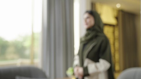 القاء التحية والسلام، التواصل الأسري والدفء الاجتماعي، ايماءات السعاده و السرور، الترحاب والكرم العربي، عائله عربيه خليجيه عمانيه ترتدي الزي التقليدي تقوم باستقبال الاصدقاء داخل غرفه المعيشه، التحدث و تبادل الاحاديث