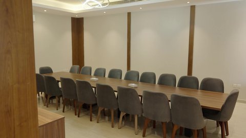 طاولة ضخمة محاطة بكراسي مريحة، التصاميم والديكورات الداخلية على الطراز الحديث، غرفة متعددة الاستخدام واسعة بأثاث أنيق، مراكز متطورة لتقديم الخدمات ، تصوير داخل شاليه راقي في سلطنة عمان