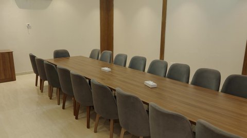 طاولة ضخمة محاطة بكراسي مريحة، التصاميم والديكورات الداخلية على الطراز الحديث، غرفة متعددة الاستخدام واسعة بأثاث أنيق، مراكز متطورة لتقديم الخدمات ، تصوير داخل شاليه راقي في سلطنة عمان