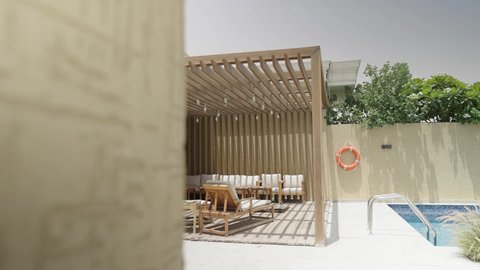 جلسة خارجية هادئة مع أثاث منزلي فاخر في احدى الشاليهات، الألعاب المائية الترفيهيه بجانب حوض السباحة, التصميم الداخلي للجلسات على الطراز الحديث، تجهيز السويت بكافة المفروشات الراقية, ديكور داخلي راقي للفلل والشقق السكنية في سلطنة عمان