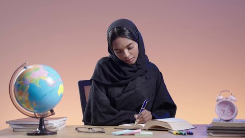 طالبة جامعية سمراء عربيه سعوديه ترتدي العباءه والحجاب تمارس هواية مطالعة الكتب المفيدة في وقت الفراغ،مفهوم محو الأمية، قضاء وقت الفراغ بالتثقيف والتعلم، التزود بالعلم والمعرفة،  القراءه بإيماءات التمعن والتركيز