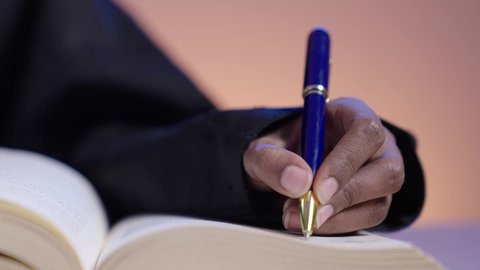 مفهوم محو الأمية، قضاء وقت الفراغ بالتثقيف والتعلم،  التزود بالعلم والمعرفة، طالبة جامعية سمراء عربيه سعوديه ترتدي العباءه والحجاب تمارس هواية مطالعة الكتب المفيدة في وقت الفراغ، القراءه بإيماءات التمعن والتركيز