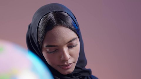 قضاء وقت الفراغ بالتثقيف والتعلم،  التزود بالعلم والمعرفة، مفهوم محو الأمية، طالبة جامعية سمراء عربيه سعوديه ترتدي العباءه والحجاب تمارس هواية مطالعة الكتب المفيدة في وقت الفراغ، القراءه بإيماءات التمعن والتركيز