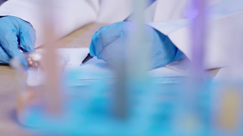 مفهوم البحوث العلمية ، العمل في القطاع الصحي في المملكة العربية السعودية، تجارب معمليه مخبريه، تصوير مقرب ليد طبيبه مخبريه عربيه خليجيه سعوديه تقوم بكتابه التحاليل والتقارير الطبية