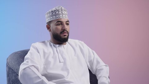 الإحساس بالإرهاق والتعب, السهر لوقت متأخر، تعابير الكسل والخمول، الحاجة للنوم والراحة, شاب عربي خليجي عماني يرتدي الدشداشه والكمه يضع يده على فمه بإيماءات التثاؤب و النعاس, خلفية ملونة