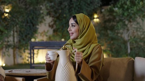 التنزه والتسلية في شاليه سياحية في وقت العطلة ، تجسيد مفهوم حسن الضيافة والكرم العربي،دلة القهوة العربية تراث قديم، اجتماع الأهل والأصدقاء في الهواء الطلق، قضاء وقت ممتع ومسلي مع مجموعة من الأصدقاء،أصدقاء عربيون خليجيون سعوديون بالزي التقليدي يشربون القهوة العربية ويتبادلون الأحاديث والقصص بإيماءات الاندماج