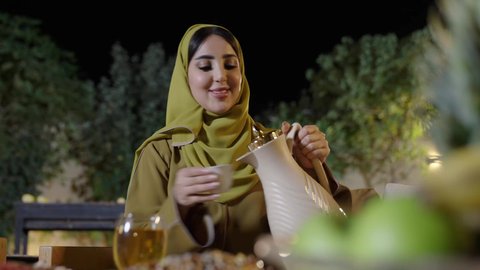 تجسيد مفهوم حسن الضيافة والكرم العربي،اجتماع الأهل والأصدقاء في الهواء الطلق، قضاء وقت ممتع ومسلي مع مجموعة من الأصدقاء،أصدقاء عربيون خليجيون سعوديون بالزي التقليدي يشربون القهوة العربية ويتبادلون الأحاديث والقصص بإيماءات الاندماج، دلة القهوة العربية تراث قديم، التنزه والتسلية في شاليه سياحية في وقت العطلة