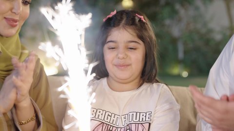 اعياد واحتفالات ومناسبات عائليه،  التنزه والتسلية في شاليه سياحي راقي وقت العطلة ،عائله عربية خليجية سعوديه ترتدي الزي التقليدي تحتفل بعيد ميلاد ابنتهم بإيماءات السعاده ،قضاء وقت ممتع ومسلي مع العائله  والأصدقاء في الهواء الطلق، فعاليات وأنشطة مسلية