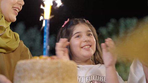 عائله عربية خليجية سعوديه ترتدي الزي التقليدي تحتفل بعيد ميلاد ابنتهم بإيماءات السعاده ،اعياد واحتفالات ومناسبات عائليه، التنزه والتسلية في شاليه سياحي راقي وقت العطلة ،  قضاء وقت ممتع ومسلي مع العائله  والأصدقاء في الهواء الطلق، فعاليات وأنشطة مسلية، التعاون والمشاركة في تحضير الطعام