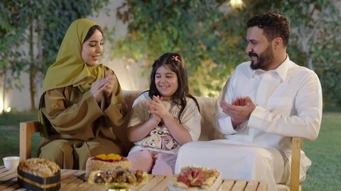 قضاء وقت ممتع ومسلي مع العائله  والأصدقاء في الهواء الطلق، فعاليات وأنشطة مسلية، التعاون والمشاركة في تحضير الطعام،عائله عربية خليجية سعوديه ترتدي الزي التقليدي تحتفل بعيد ميلاد ابنتهم بإيماءات السعاده ، التنزه والتسلية في شاليه سياحي راقي وقت العطلة