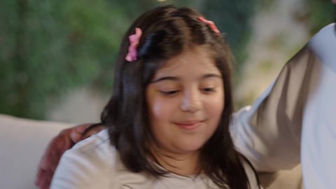 فعاليات وأنشطة مسلية، التعاون والمشاركة في تحضير الطعام،  قضاء وقت ممتع ومسلي مع العائله  والأصدقاء في الهواء الطلق، عائله عربية خليجية سعوديه ترتدي الزي التقليدي تحتفل بعيد ميلاد ابنتهم بإيماءات السعاده ، التنزه والتسلية في شاليه سياحي راقي وقت العطلة