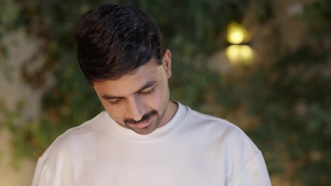 تحضير الشواء في التجمعات، فعاليات وأنشطة مسلية، التعاون والمشاركة في تحضير الطعام، تصوير مقرب لولد عربي خليجي سعودي يرتدي الزي الكاجوال ويقوم بعملية الشواء تقليب اللحم على الموقد التأكد من طهيه جيدا، التنزه والتسلية في شاليه سياحي راقي وقت العطلة