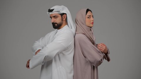 تعابير وايماءات الثقة بالنفس، الوقوف باستقامة وأيدي متقاطعة، بورتريه  لزوجين عربيين خليجيين إماراتيين يرتديان الزي الاماراتي ينظران إلى الكاميرا، مفهوم الأناقة والاهتمام بالمظهر الخارجي، خلفية بيضاء