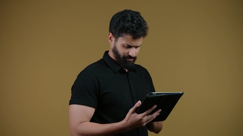 Using modern and advanced technology, using a tablet, a picture of an Arab Gulf Emirati man wearing casual clothes holding a tablet in his hand, yellow background