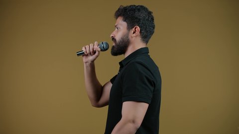 الاندماج مع الأغنية، مواهب غنائية فنية،تسجيل مقطع صوتي غنائي،  تصوير لشاب عربي خليجي اماراتي يرتدي الزي الكاجوال يقوم بالغناء باستخدام الميكروفون بتعابير الحماس,  خلفيه صفراء