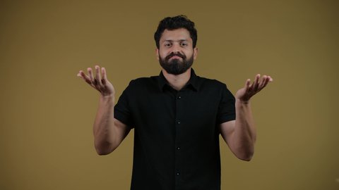 السخرية من موضوع مبهم،  الاستغراب والاستفسار عن أمر ما،تصوير لشاب عربي خليجي إماراتي يرتدي الزي الكاجوال ينظر إلى الكاميرا ويرفع يديه نحو الأعلى بإيماءات عدم المعرفة, التردد وعدم الثقة، الشعور بالحيرة والغموض، خلفية صفراء