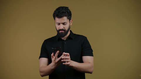 دمج التقنيات الحديثة والتكنولوجيا بالحياة العملية, التواصل مع الأهل والأصدقاء, متابعة آخر الأخبار والمستجدات حول العالم, تصوير لشاب عربي خليجي اماراتي يرتدي الزي الكاجوال يقوم باستخدام الهاتف المحمول، خلفية صفراء
