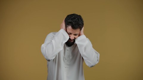 تلقي اخبار سعيدة غير متوقعة،  الشعور بالدهشة والذهول,النظر إلى الكاميرا بايماءات الصدمة والتعجب والانبهار, التفاجؤ من موقف محدد، تذكر شيء ما، تصوير لرجل عربي خليجي اماراتي يرتدي الكندورة يضع يديه على رأسه، خلفية صفراء