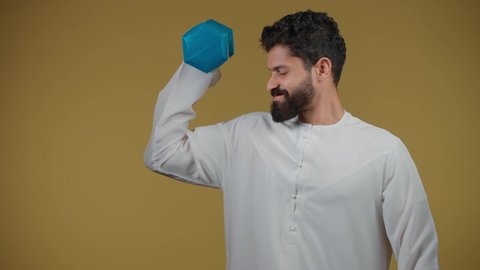 رفع الأثقال (دمبلز), بناء جسم صحي, حرق الدهون والسعرات الحرارية, نشاط بدني للمحافظه على الصحه واللياقه الجسديه,تصوير لرجل عربي خليجي اماراتي يرتدي الكندورة يحمل الاوزان الحديديه، خلفية صفراء