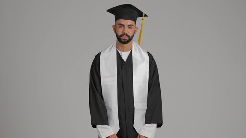 تعابير الجهل وعدم المعرفة، مناسبة النجاح في الجامعة، مفهوم الاجتهاد والتفوق،الاحتفال بإنهاء الدراسة الجامعية، الوصول لحلم النجاح، جودة التعليم في الامارات، تصوير لشاب خريج عربي خليجي اماراتي مبتسم يرتدي عباءة وقبعة التخرج  ، خلفية رماديه