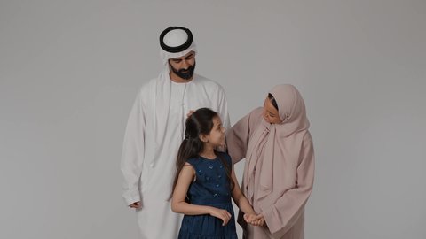 تقوية الرابط الأسري بين الأهل والأبناء، مشاركة الأوقات الممتعة مع الأبناء، المشي و التنزه مع الأطفال، بورتريه لام عربيه خليجيه اماراتية ترتدي العباءه الملونه تقوم بقضاء وقت ممتع برفقه ابنتها و زوجها