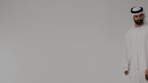 Pointing to something, summer vacation tourism, portrait of an Emirati Gulf Arab family wearing traditional dress preparing for a fun summer trip, a Gulf woman holding a travel bag in her hands with gestures of happiness and pleasure