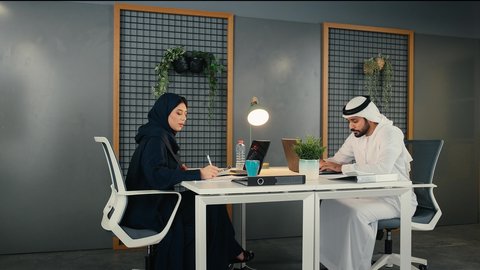 تعلم اساليب العمل والتطوير المهني، العمل الجماعي وروح الفريق الواحد، وضع الخطط الاستراتيجية لتحقيق الأهداف، مفهوم الإدارة المتعاونة، زملاء عمل عربيون خليجيون اماراتيون يجلسون داخل مقر الشركة ، مهن ووظائف ادارية مكتبية، المساواة بين الرجل الامرأة