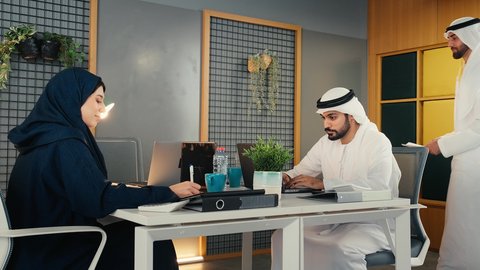الوحدة والعمل الجماعي, دمج الأجهزة التقنية الحديثة بالأعمال المكتبية، دراسة أوراق البيانات الإحصائية, تطوير المشاريع و الاستثمارات, إدارة و تقسيم المهام، تصوير لفريق عمل عربي خليجي اماراتي  يقوم بإجراء اجتماع عمل داخل غرفة الاجتماعات في مقر الشركة