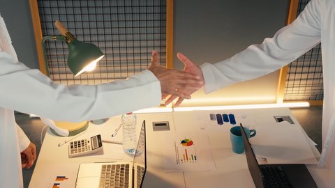 مكاتب وشركات في الامارات العربية ، عقد اتفاقيات وصفقات جديده, الإتفاق على المشاريع التجارية، تصوير مقرب لأيدي رجال أعمال عرب خليجيين اماراتيين يقومون بمصافحة بعضهم داخل مقر العمل، الشراكة والتعاون في إنجاز المهام