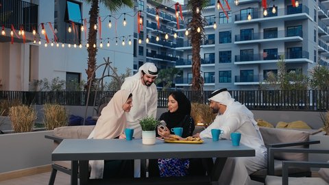 قضاء اوقات ممتعة في عطلة نهاية الاسبوع، التقاط صور السيلفي التذكارية عبر الهاتف المحمول ،  الاستمتاع بالمشروبات الساخنه، التسامر والدردشة مع الأصدقاء، جلسات تعارف وديه، أصدقاء عرب خليجيين اماراتيين يستمتعون بتبادل الحديث في احد المقاهي الاماراتية