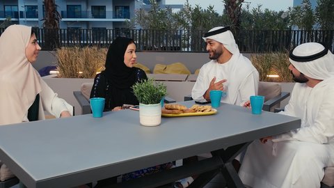 الاستمتاع بالمشروبات الساخنه، التسامر والدردشة مع الأصدقاء، ديوانية اماراتية ونقاشات وحوارات وقضاء أوقات ممتعة، جلسات تعارف وديه، أصدقاء عرب خليجيين اماراتيين يستمتعون بتبادل الحديث في احد المقاهي الاماراتية، امراة عربيه خليجيه اماراتية تمسك بيدها الهاتف المحمول