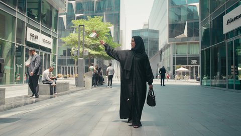 الإحتفال باليوم الوطني الإماراتي، العيد الوطني الإماراتي ، يوم استقلال الإمارات ، مفهوم حب الوطن ، تصوير لمرأة عربية خليجية إماراتية ترتدي العباءة والحجاب ، تحمل علم الإمارات العربية المتحدة