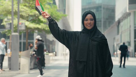 UAE Independence Day, concept of patriotism, illustration of an Emirati Gulf Arab woman wearing an abaya and hijab, holding the UAE flag, UAE National Day, celebration of UAE National Day