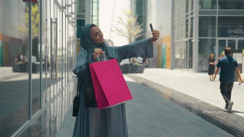 مفهوم الموضه والأناقه،عباءات خليجيه نسائيه عصريه، مفهوم التصوير والشهره عبر مواقع التواصل الاجتماعي،  تصوير لشابة عربية خليجية اماراتية ترتدي العباءة والحجاب ،  سيدة سعودية تستمتع بمتعة التسوق، شراء الملابس و الاكسسوارات النسائيه