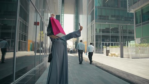 عباءات خليجيه نسائيه عصريه، مفهوم التصوير والشهره عبر مواقع التواصل الاجتماعي،  تصوير لشابة عربية خليجية اماراتية ترتدي العباءة والحجاب ، مفهوم الموضه والأناقه، سيدة سعودية تستمتع بمتعة التسوق، شراء الملابس و الاكسسوارات النسائيه