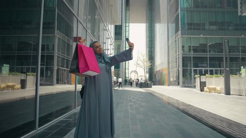 مفهوم التصوير والشهره عبر مواقع التواصل الاجتماعي،  عباءات خليجيه نسائيه عصريه، تصوير لشابة عربية خليجية اماراتية ترتدي العباءة والحجاب ، مفهوم الموضه والأناقه، سيدة سعودية تستمتع بمتعة التسوق، شراء الملابس و الاكسسوارات النسائيه