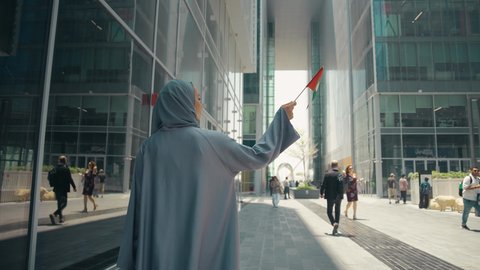 العيد الوطني الإماراتي ، الإحتفال باليوم الوطني الإماراتي، مفهوم حب الوطن ، يوم استقلال الإمارات ، تصوير لمرأة عربية خليجية إماراتية ترتدي العباءة والحجاب ، تحمل علم الإمارات العربية المتحدة