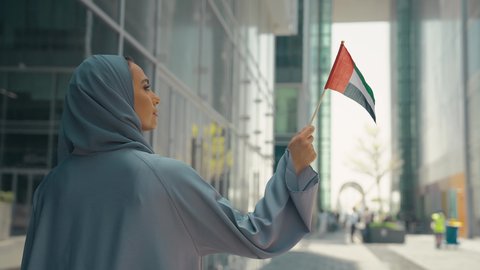 الإحتفال باليوم الوطني الإماراتي، مفهوم حب الوطن ، يوم استقلال الإمارات ، العيد الوطني الإماراتي ، تصوير لمرأة عربية خليجية إماراتية ترتدي العباءة والحجاب ، تحمل علم الإمارات العربية المتحدة