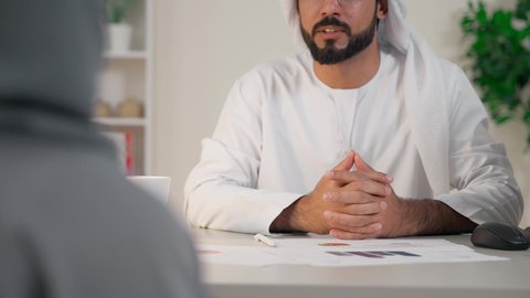 التفاهم والتعاون بين الزملاء ووضع الخطط الاستراتيجية، عقد اجتماع داخل مقر الشركة، موظفان عربيان خليجيان اماراتيان يتعلمان اساليب العمل والتطوير المهني، تبادل الخبرات والمعلومات لتحقيق الاهداف، روح الفريق الواحد والعمل الجماعي، تصوير من الخلف لموظفة محجبة