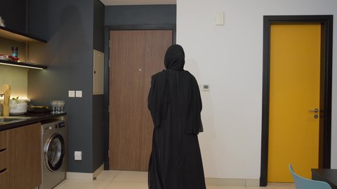 إحضار الحاجات واللوازم المنزلية، الاستعداد للذهاب إلى دوام العمل بنشاط, رجل عربي خليجي اماراتي يرتدي الكندورة والغترة يأتي إلى منزله, الاهتمام بالأناقة والمظهر الخارجي، سيده اماراتية تقوم باستقبال زوجها اثناء عودته من  العمل بإيماءات السرور والسعادة