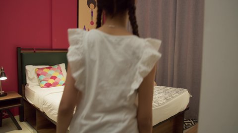 تعزيز الروابط العائلية، مفهوم التربيه القائمه على الحب والحنان، ام سعودية تقوم بقضاء وقت ممتع مع الابنه، المشاركه بقراءه القصص المفيده مع الأبناء قبل النوم، بامراة عربيه خليجيه اماراتية ترتدي العباءه السوداء تجلس على السرير برفقه ابنتها تقرأ الروايات المسليه