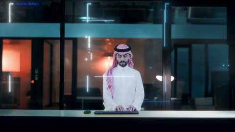 العمل في الشركات التكنولوجية الحديثة، رجل عربي سعودي خليجي يرتدي الشماغ والثوب يضع سماعة الرأس يقوم بالكتابة على ازرار لوحة المفاتيح، شاشة هولوجراميه ثلاثية الأبعاد, تطور نظام العمل مع التقنيه والتكنولوجيا الحديثه