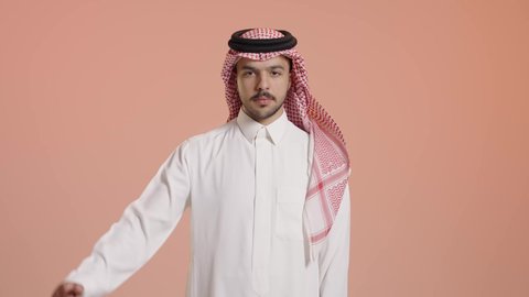 القلق والفشل في تحقيق أمر ما، مفهوم التقييم السلبي والانزعاج، بورتريه لرجل عربي خليجي إماراتي يرتدي الثوب التقليدي والشماغ  ينظر الى الكاميرا يشير بإصبع الابهام الى الاسفل بإيماءات الانزعاج، تعابير الرفض وعدم القبول والرضا